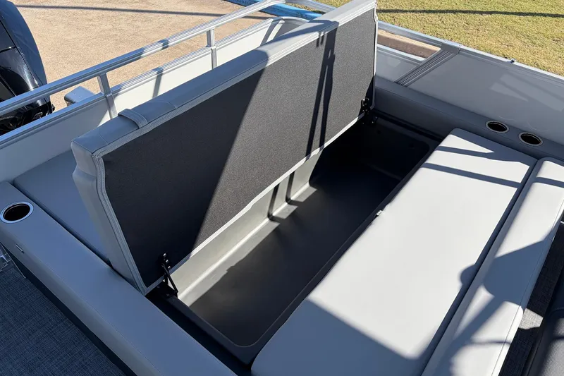 Slide: The Image of 2026 Sun Tracker Party Barge 22 RF XP3 storage compartment with open seat and cup holders. - 49