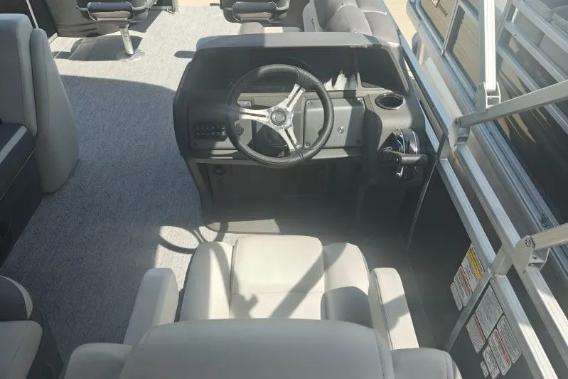Slide: The Image of 2026 Sun Tracker Fishin' Barge 20 DLX interior with steering wheel and seating. - 14