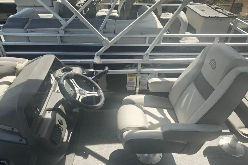Slide: The Image of 2026 Sun Tracker Fishin' Barge 20 DLX interior with steering wheel and seating. - 15