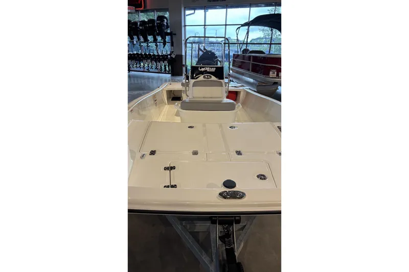 Slide: The Image of 2026 Mako Pro Skiff 15 CC boat interior, showcasing spacious deck and seating in showroom. - 3
