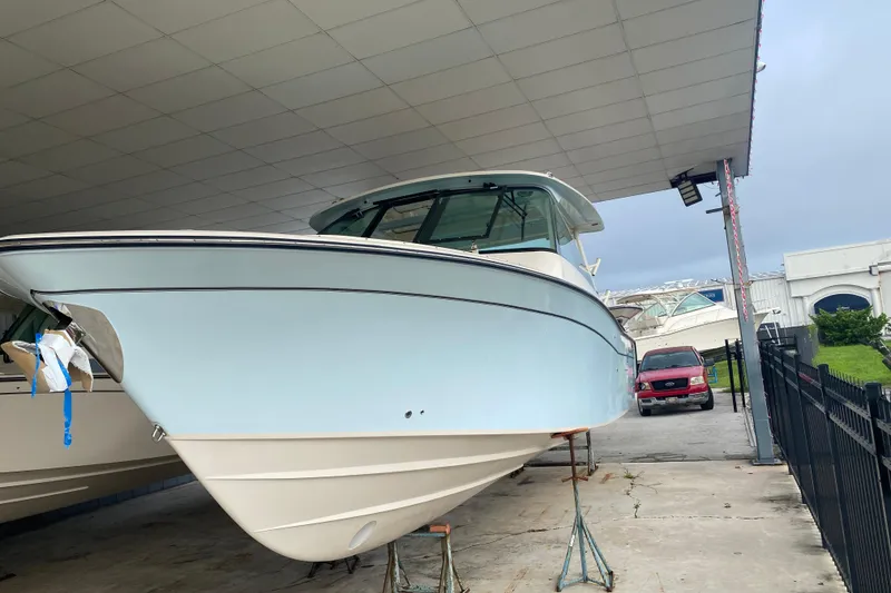 Slide: The Image of 2025 Grady-White Freedom 345 boat displayed in a covered marina area. - 1