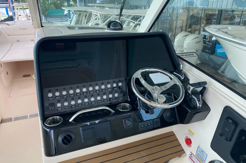 Slide: The Image of 2025 Grady-White Freedom 345 boat dashboard with steering wheel and control panel. - 12