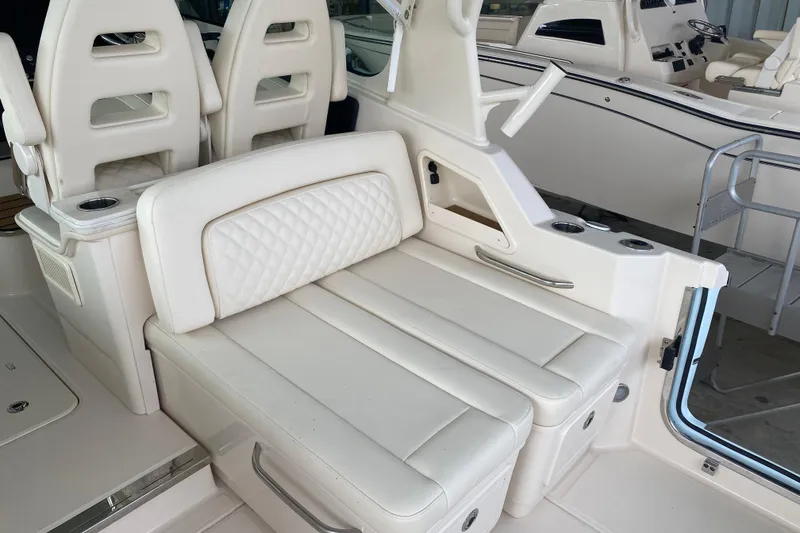 Slide: The Image of 2025 Grady-White Freedom 345 boat interior with white cushioned seating and cup holders. - 15