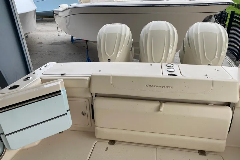 Slide: The Image of 2025 Grady-White Freedom 345 boat with triple engines, docked in a marina. - 17