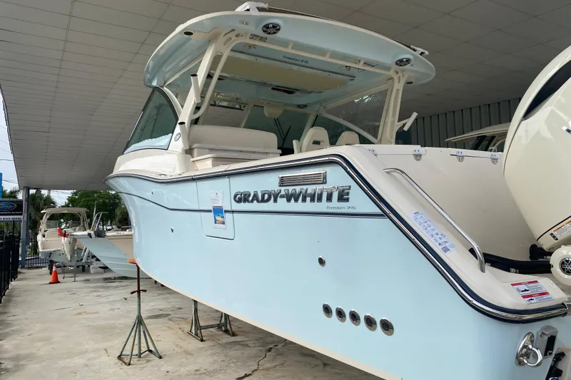 Slide: The Image of 2025 Grady-White Freedom 345 boat displayed in a showroom, side view. - 2