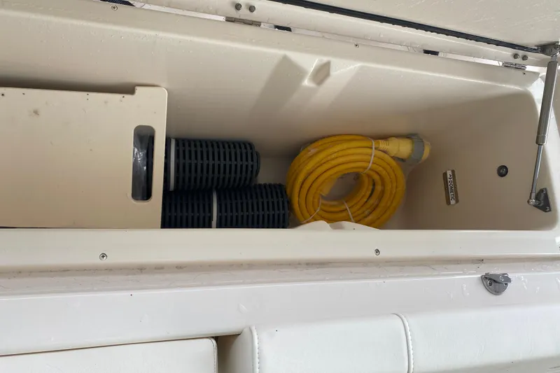 Slide: The Image of Storage compartment in a 2025 Grady-White Freedom 345 boat with hose and accessories. - 20