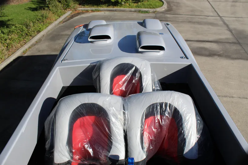 Slide: The Image of 2007 Chaudron 41 SS boat with red and gray seats, parked on concrete. - 35