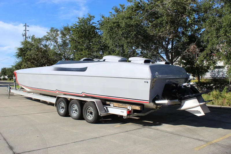Slide: The Image of 2007 Chaudron 41 SS powerboat on trailer, parked outdoors with trees in background. - 6