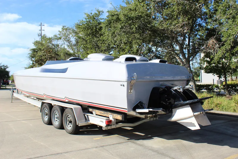 Slide: The Image of 2007 Chaudron 41 SS powerboat on trailer, parked outdoors, surrounded by trees. - 7