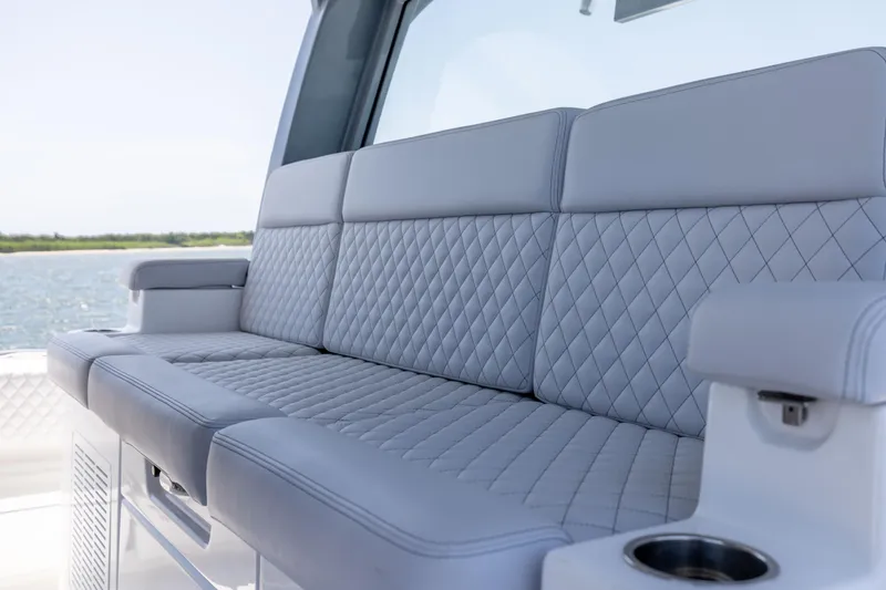 Slide: The Image of Luxurious seating on 2026 HCB 48 Campeon boat with quilted upholstery and cup holder. - 21