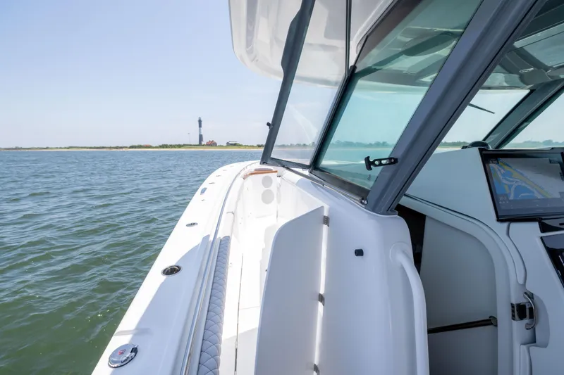 Slide: The Image of 2026 HCB 48 Campeon boat with open cabin, navigating near a lighthouse. - 27