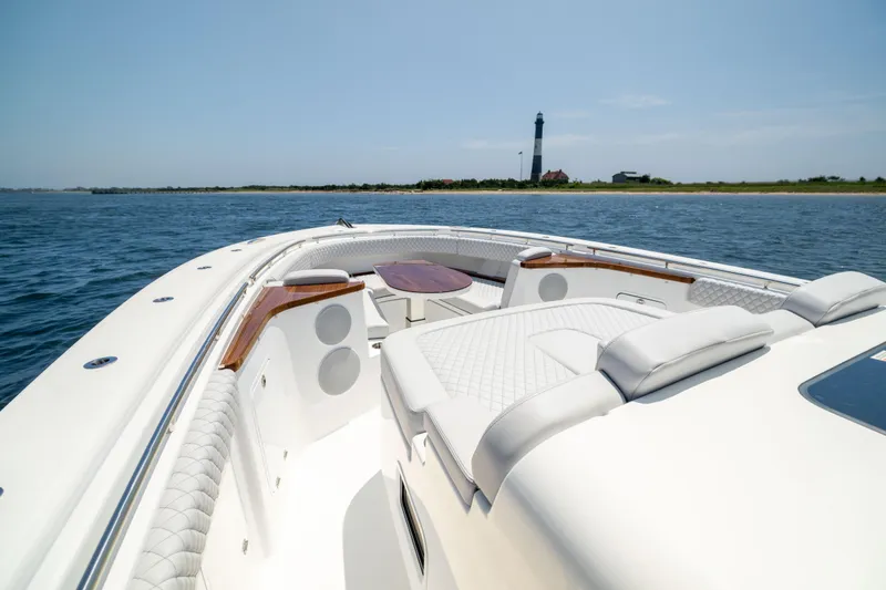 Slide: The Image of Luxurious 2026 HCB 48 Campeon boat cruising near a scenic lighthouse. - 29