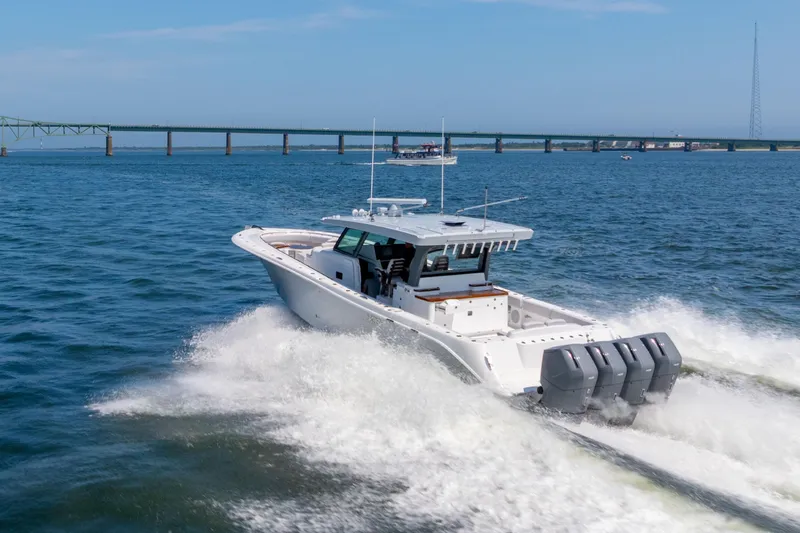 Slide: The Image of 2026 HCB 48 Campeon boat cruising on calm waters near a scenic shoreline. - 3