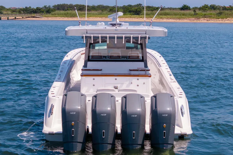 Slide: The Image of 2026 HCB 48 Campeon boat cruising on open water near a bridge. - 4