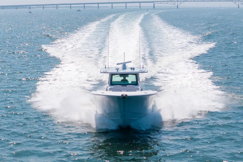 Slide: The Image of HCB 48 Campeon 2026 cruising on open water with bridge in background. - 8