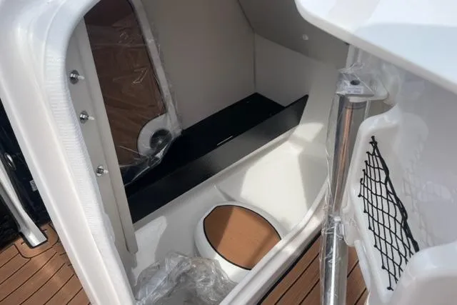 Slide: The Image of 2025 Yamaha Boats 252S interior cabin with seating and storage. - 11
