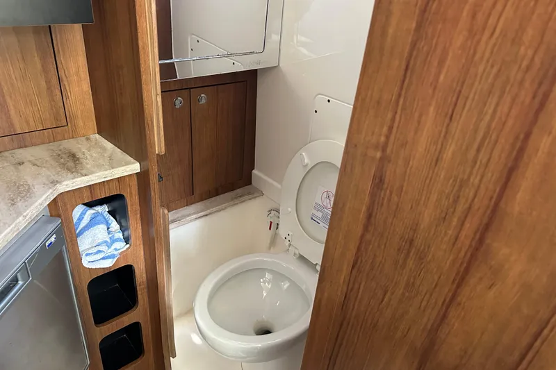 Slide: The Image of Compact bathroom in 2018 Invincible 42 boat with wooden cabinetry and modern fixtures. - 13