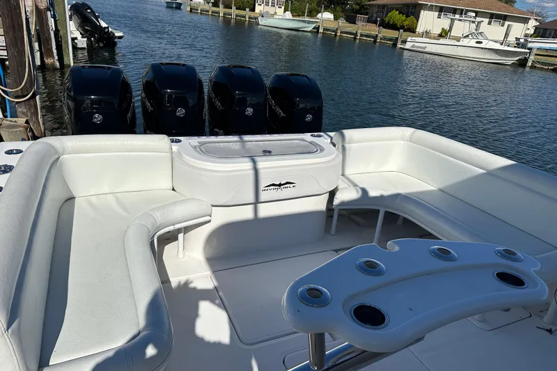 Slide: The Image of Luxurious 2018 Invincible 42 boat interior with white seating and multiple outboard engines. - 8
