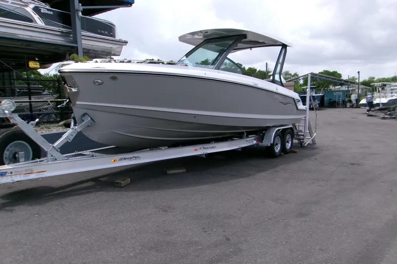 The Image of 2026 Monterey Elite 27 OB boat on trailer, parked outdoors, showcasing sleek design. - 0
