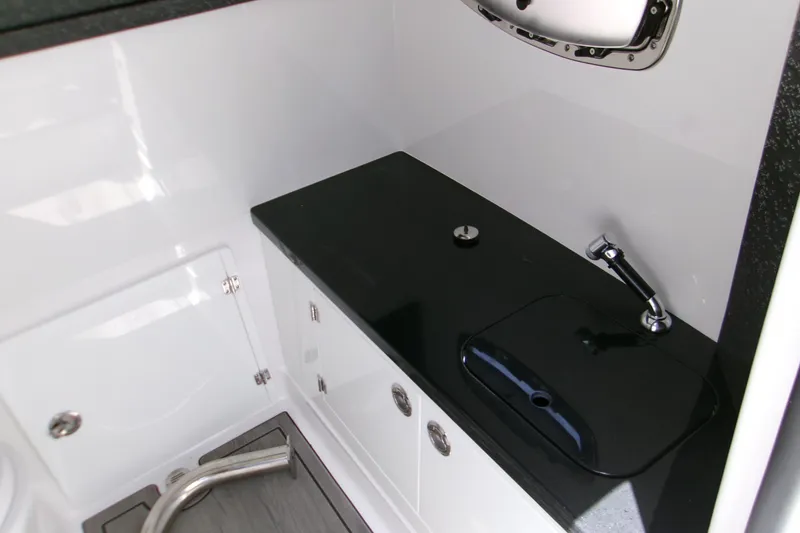 Slide: The Image of Interior of 2026 Monterey Elite 27 OB boat featuring sleek black countertop and modern fixtures. - 16