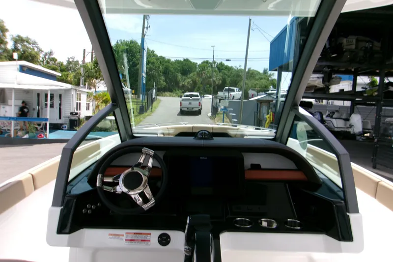 Slide: The Image of Interior view of 2026 Monterey Elite 27 OB boat dashboard at a marina. - 20