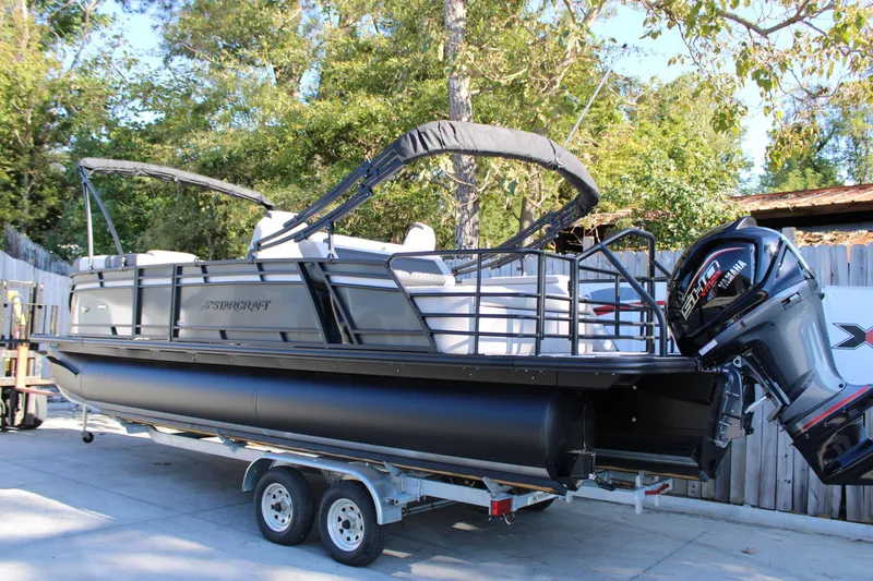 Slide: The Image of 2026 Starcraft SLS 3 Q DH pontoon boat on trailer, parked outdoors. - 3