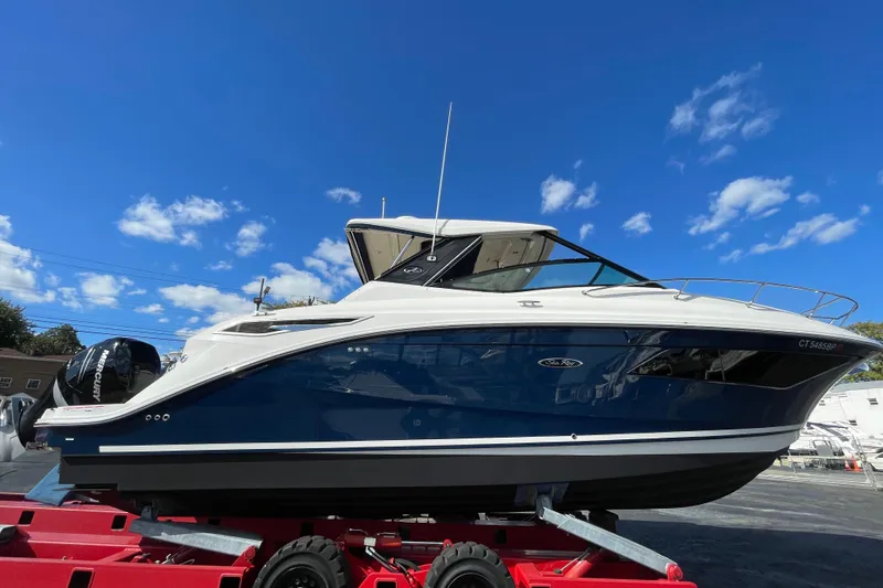 Slide: The Image of 2020 Sea Ray Sundancer 320 boat on trailer under clear blue sky. - 1