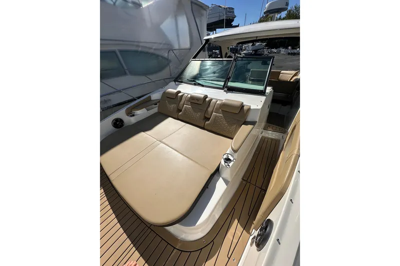 Slide: The Image of 2020 Sea Ray Sundancer 320 boat interior with tan seating and wood flooring. - 10