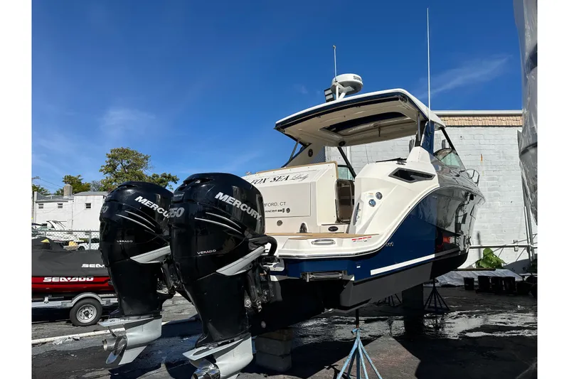 Slide: The Image of 2020 Sea Ray Sundancer 320 with twin Mercury Verado engines, displayed outdoors. - 16