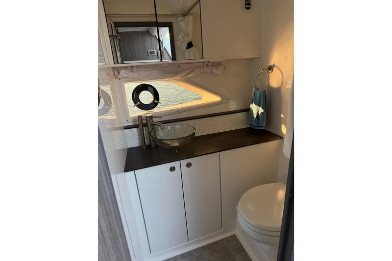 Slide: The Image of 2020 Sea Ray Sundancer 320 bathroom with modern sink, mirror, and porthole window. - 17