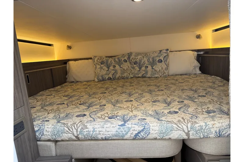 Slide: The Image of 2020 Sea Ray Sundancer 320 cabin with cozy bed and nautical-themed bedding. - 18