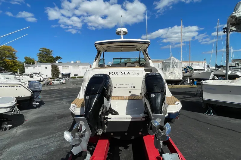 Slide: The Image of 2020 Sea Ray Sundancer 320 boat on trailer, marina background, clear blue sky. - 29