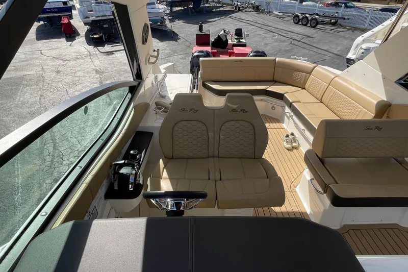 Slide: The Image of 2020 Sea Ray Sundancer 320 interior with tan seating and helm, docked at marina. - 36