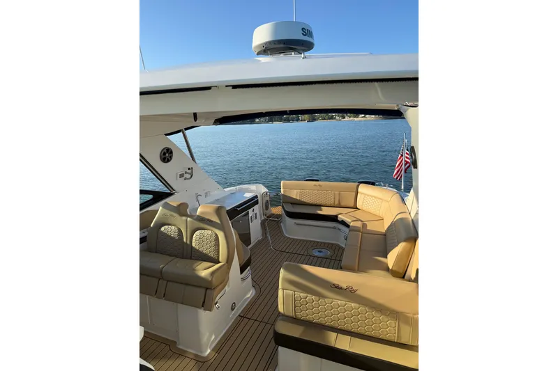 Slide: The Image of 2020 Sea Ray Sundancer 320 yacht interior with tan seating, overlooking serene water. - 4