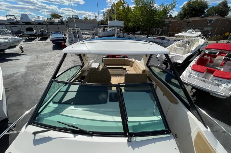 Slide: The Image of 2020 Sea Ray Sundancer 320 boat with open deck and seating, docked in a marina. - 42