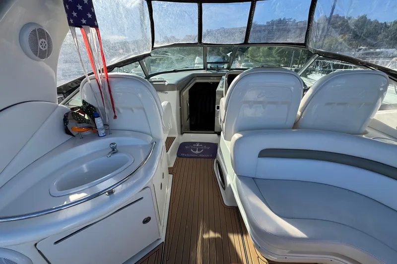 Slide: The Image of 2007 Sea Ray 340 Sundancer interior with seating, sink, and American flag. - 12