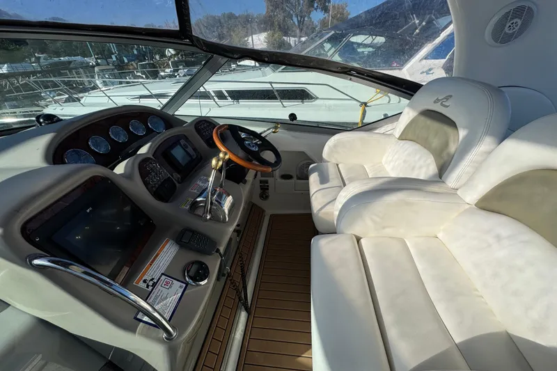 Slide: The Image of 2007 Sea Ray 340 Sundancer cockpit with luxurious white seating and modern dashboard controls. - 14