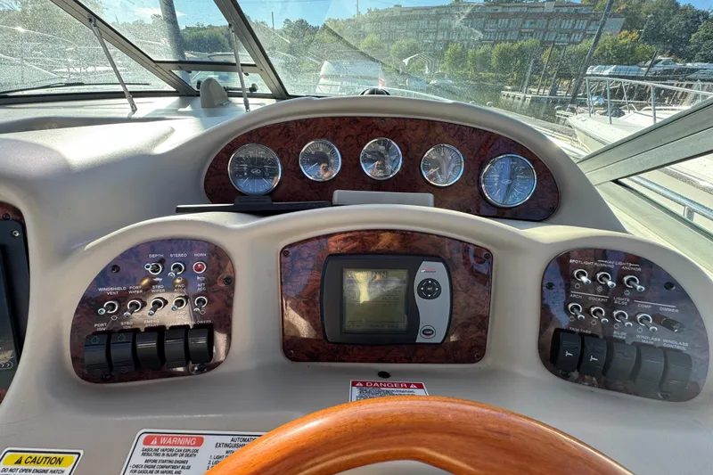 Slide: The Image of 2007 Sea Ray 340 Sundancer dashboard with gauges and controls, featuring wood accents and navigation system. - 16