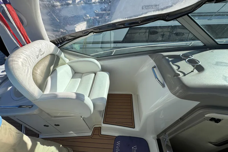 Slide: The Image of 2007 Sea Ray 340 Sundancer cockpit with white captain's chair and wooden flooring. - 18