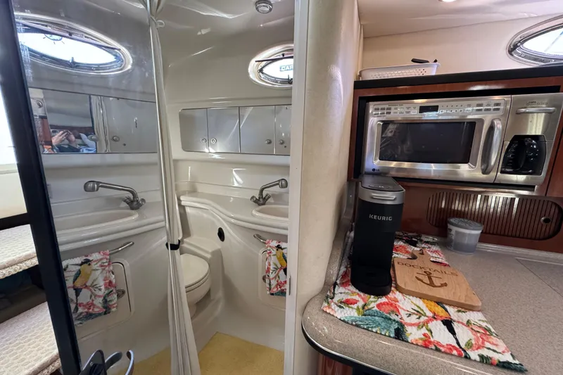 Slide: The Image of Interior of 2007 Sea Ray 340 Sundancer with kitchenette and bathroom, featuring modern appliances. - 29
