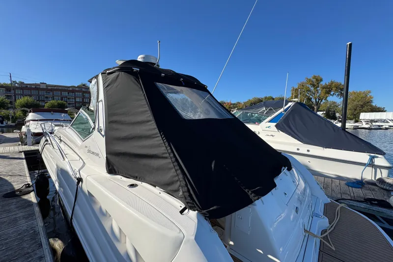 Slide: The Image of 2007 Sea Ray 340 Sundancer docked, featuring a black canvas cover under a clear blue sky. - 5