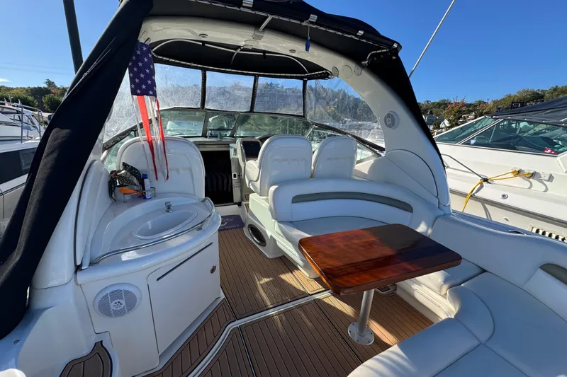 Slide: The Image of 2007 Sea Ray 340 Sundancer interior with seating, table, and sink on a sunny day. - 9