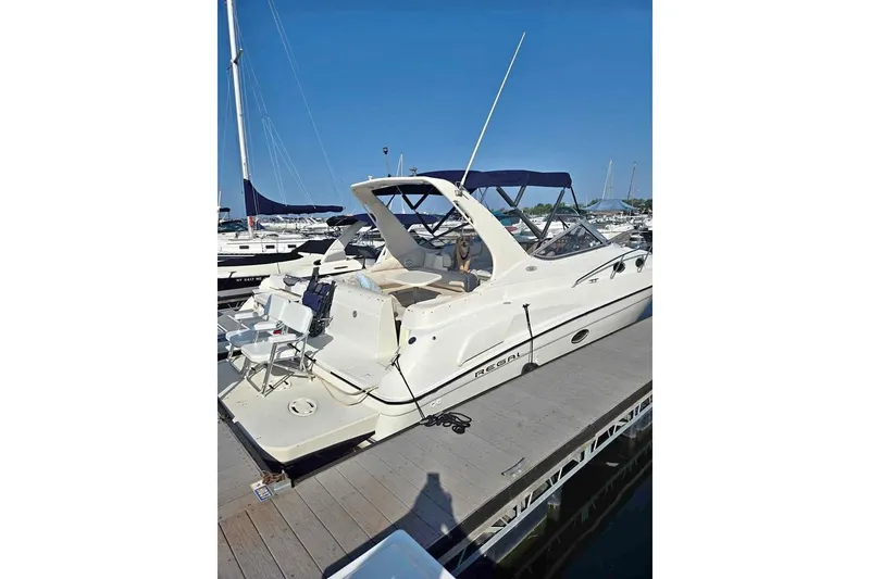 The Image of 1998 Regal Commodore 3060 boat docked at marina under clear blue sky. - 1