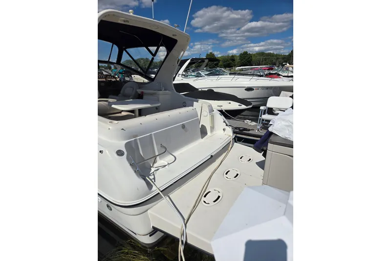 Slide: The Image of 1998 Regal Commodore 3060 boat docked, featuring spacious deck and seating under clear skies. - 3