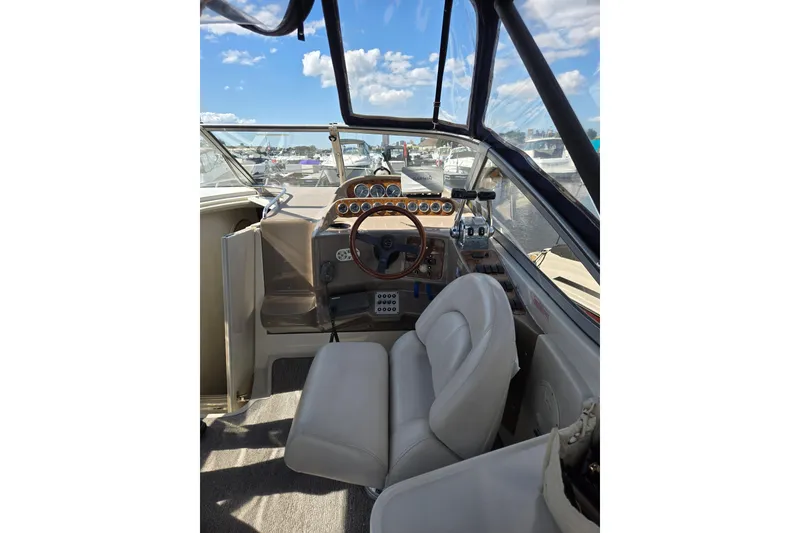 Slide: The Image of 1998 Regal Commodore 3060 boat cockpit with steering wheel and controls, under a clear blue sky. - 4