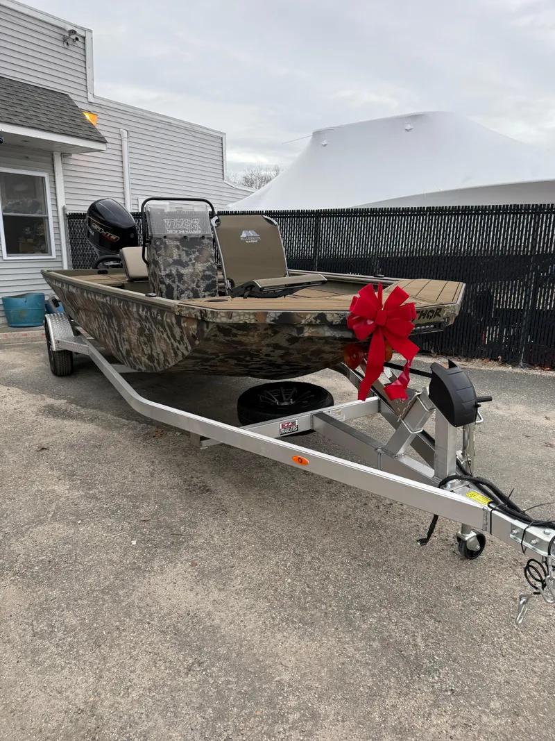 Slide: The Image of 2025 Thor 1900 boat with camouflage design and red bow on trailer. - 1