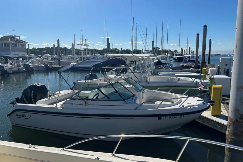 The Image of 2006 Boston Whaler 210 Ventura docked at a marina, surrounded by other boats. - 0