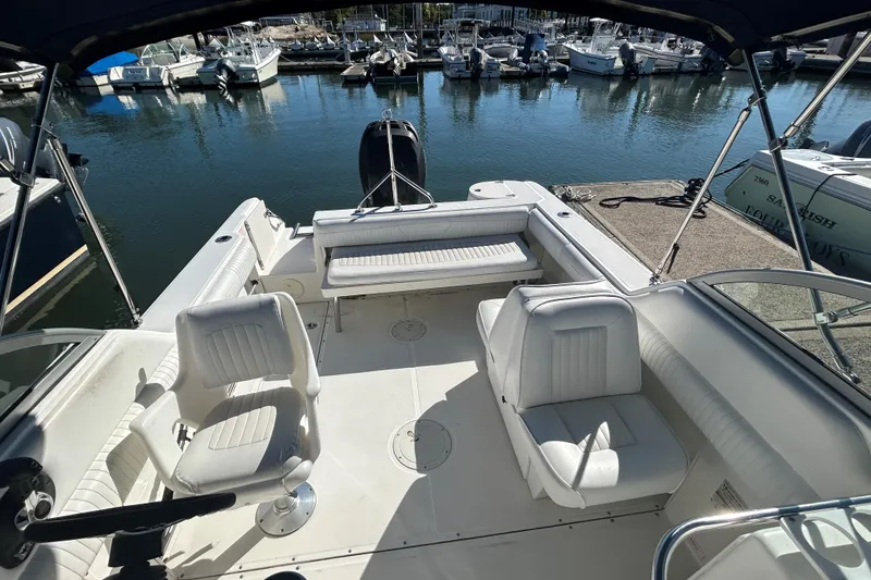 Slide: The Image of 2006 Boston Whaler 210 Ventura boat interior with white seating, docked at marina. - 13