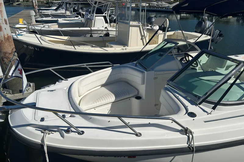 Slide: The Image of 2006 Boston Whaler 210 Ventura boat docked at marina, featuring sleek design and spacious seating. - 3