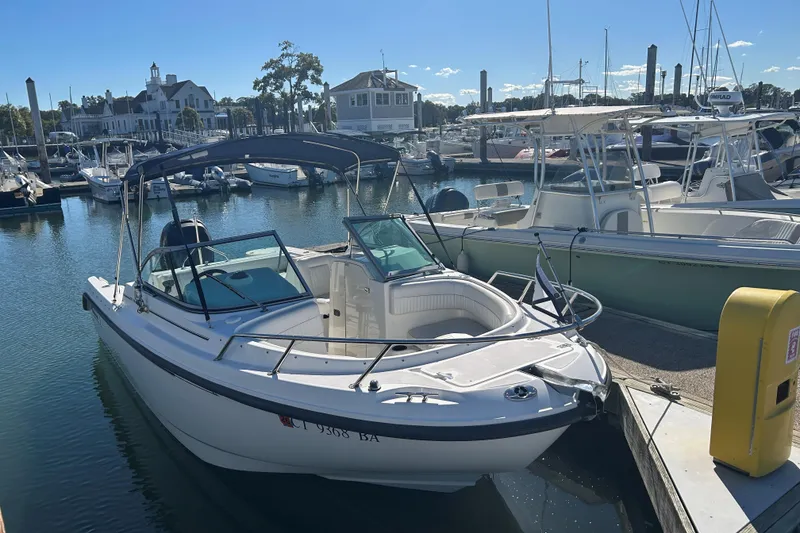 Slide: The Image of 2006 Boston Whaler 210 Ventura docked at a marina under clear skies. - 4